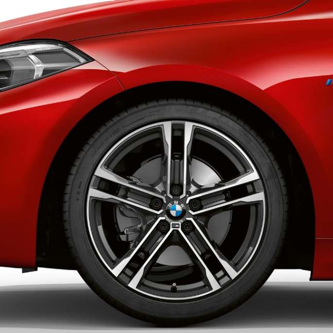 BMW Serie 1, Versione M Sport, vista laterale/frontale. BMW Serie 1, Versione M Sport in Melbourne Red metallizzato, vista laterale/frontale con cerchio in lega leggera da 17" M, styling a doppi raggi nº 550 M bicolore.