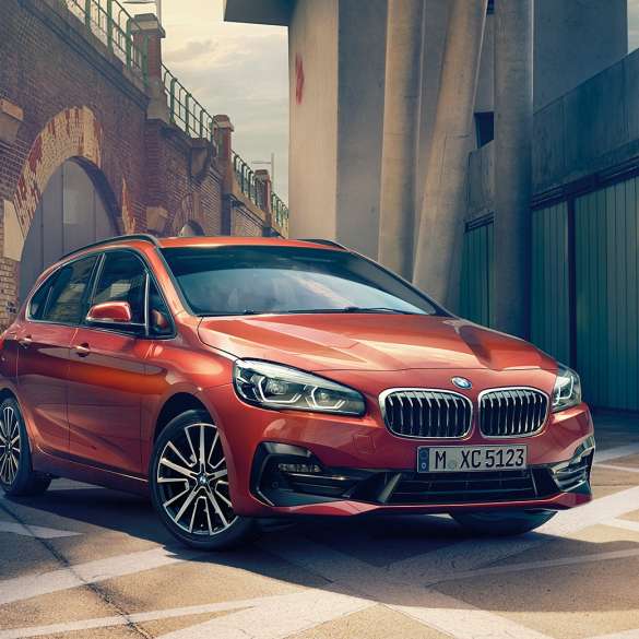 Esterni della BMW Serie 2 Active Tourer F45 BMW Serie 2 Active Tourer F45 Facelift 2018 Sunset Orange metallizzato vista anteriore a tre quarti parcheggiata in strada
