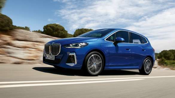 Nuova BMW Serie 2 Active Tourer 230e ibrida Plug-in U06 2021 in movimento su strada provinciale Nuova BMW Serie 2 Active Tourer 230e ibrida Plug-in U06 2021 M Portimao Blue metallizzato Vista laterale a tre quarti in movimento su strada provinciale