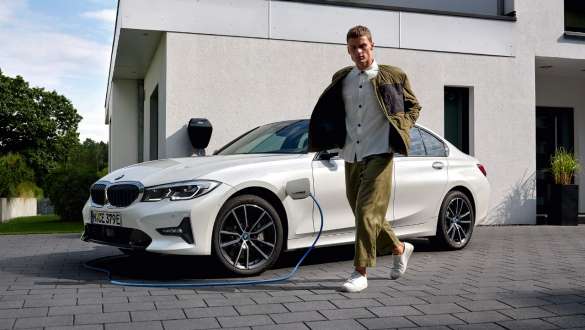 BMW Serie 3 Berlina ibrida Plug-in 2021 G20 Vista laterale a tre quarti in ricarica BMW Serie 3 Berlina ibrida Plug-in 2021 G20 Vista anteriore a tre quarti in ricarica con modella