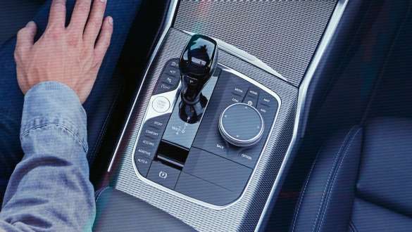 BMW Serie 3 Berlina (G20), cambio sportivo Steptronic. Primo piano con prospettiva a volo di uccello della consolle centrale della BMW Serie 3 Berlina (G20) con pomello del cambio e cambio sportivo Steptronic.
