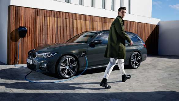 BMW Serie 3 Touring ibrida Plug-in 2021 G21 Vista laterale a tre quarti con BMW Wallbox BMW Serie 3 Touring ibrida Plug-in 2021 G21 Vista laterale a tre quarti con BMW Wallbox e modella