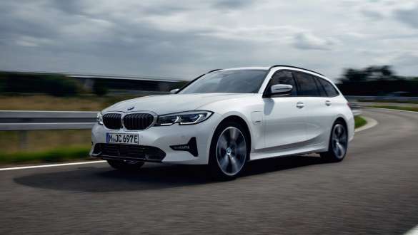 BMW Serie 3 Touring ibrida Plug-in 2021 G21 Vista anteriore a tre quarti in movimento BMW Serie 3 Touring ibrida Plug-in 2021 G21 Vista anteriore a tre quarti in movimento su strada