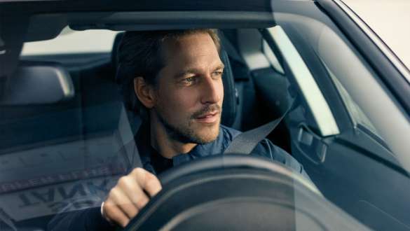 Uomo al volante di una BMW Serie 5 Berlina G30 Uomo al volante visto attraverso il parabrezza della BMW Serie 5 Berlina G30