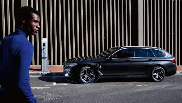 BMW Serie 5 Touring ibrida Plug-in 2021 G31 Vista laterale in ricarica BMW Serie 5 Touring ibrida Plug-in 2021 G31 Vista laterale in ricarica con modella