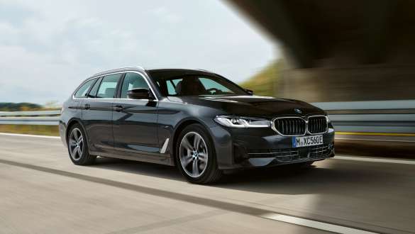BMW Serie 5 Touring ibrida Plug-in 2021 G31 Vista anteriore a tre quarti in movimento BMW Serie 5 Touring 2021 ibrida Plug-in G31 Vista anteriore a tre quarti in movimento su strada
