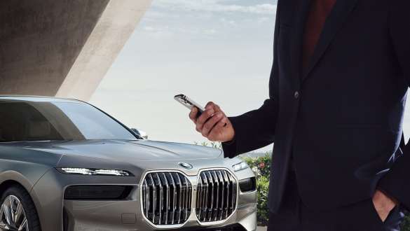 Una persona tiene il proprio smartphone vicino alla maniglia della portiera Una persona tiene il proprio smartphone vicino alla maniglia della portiera