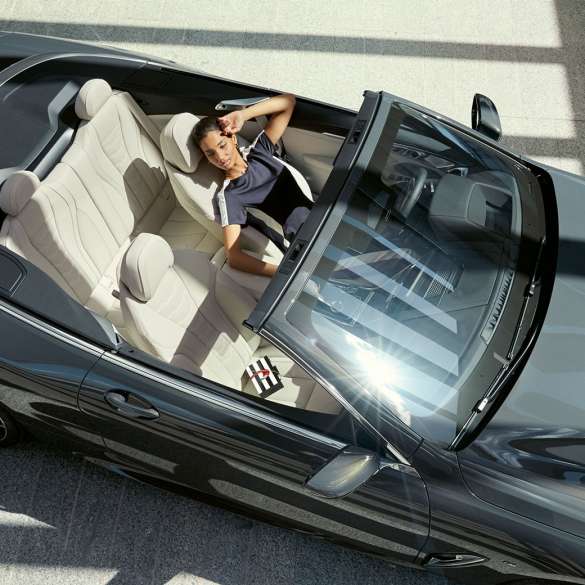 Interni della BMW M850i xDrive con donna alla guida vista dall’alto, sedili multifunzione in pelle Merino Ivory White G14 Interni della BMW M850i xDrive con donna alla guida vista dall’alto, sedili multifunzione in pelle Merino Ivory White G14
