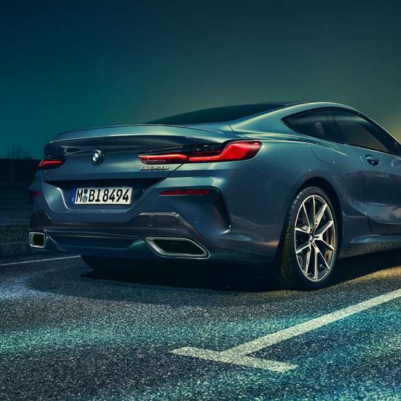 BMW Serie 8 M Coupé, vista posteriore a tre quarti G15. BMW Serie 8 Coupé, vista posteriore a tre quarti, ripresa da ferma, di notte G15.