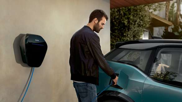 BMW i3 presso una stazione di ricarica pubblica in Jucaro Beige con profilo in Frozen Grey metallizzato Una coppia ricarica la propria BMW i3 presso una stazione di ricarica pubblica I01 2018 in Jucaro Beige con profilo in Frozen Grey metallizzato