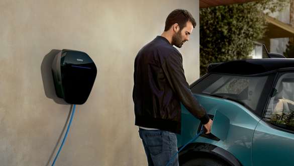 Un uomo ricarica la propria BMW i3 I01 2018 al BMW Wallbox Un uomo con il cavo di ricarica BMW Wallbox BMW i3 I01 2018 Blue Ridge Mountain con profilo in Frozen Grey metallizzato