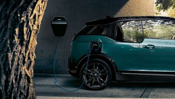 BMW i3 I01 2018 vicino al BMW Wallbox BMW i3 I01 2018 Blue Ridge Mountain con profilo in Frozen Grey metallizzato in ricarica vicino alla BMW Wallbox.