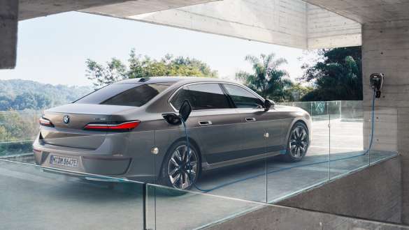 Vista posteriore a tre quarti della BMW i7 Berlina G70 in ricarica domestica Vista posteriore a tre quarti in ricarica domestica con Wallbox della BMW i7 Berlina G70 BMW Individual Oxid grey metallizzato