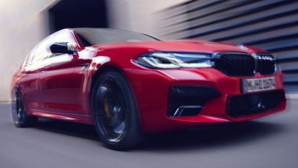 BMW M5 Competition con M xDrive F90 2020 Vista anteriore a tre quarti BMW M5 Competition con M xDrive F90 LCI Facelift 2020 BMW Individual Imola Red Vista anteriore a tre quarti in movimento