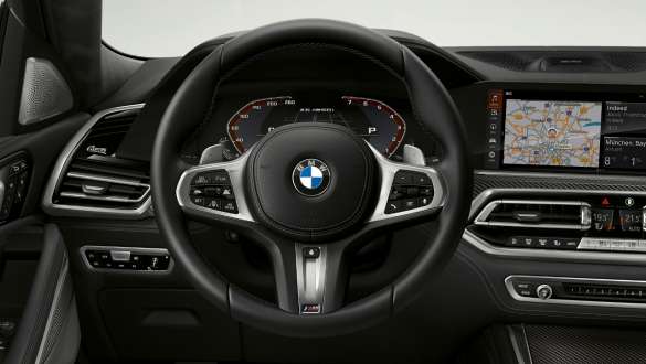 Interni con primo piano del volante in pelle M. Ripresa degli interni della BMW X6 M50i con primo piano del volante in pelle M.