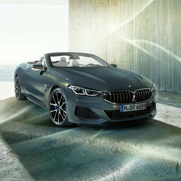 BMW M850i xDrive Cabrio, vista frontale di tre quarti G14. BMW M850i xDrive Cabrio in Dravit Grey metallizzato con capote aperta, vista frontale di tre quarti, in sosta davanti alla costa G14.