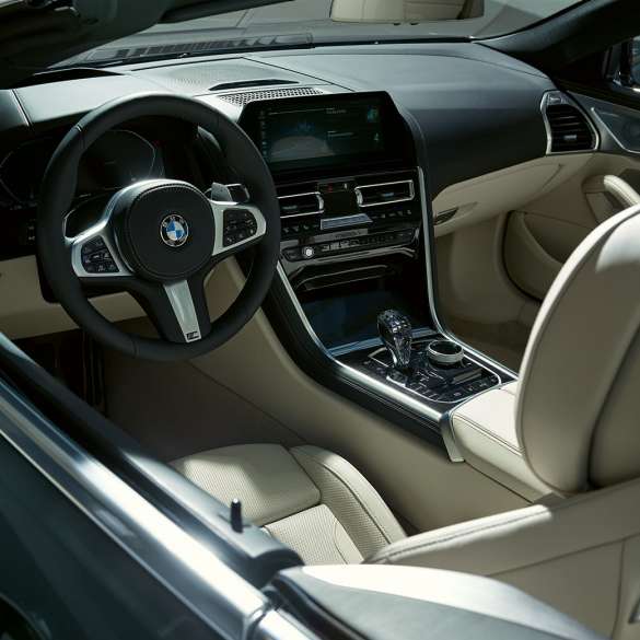 BMW M850i xDrive Cabrio, cockpit G14. BMW M850i xDrive Cabrio in Dravit Grey metallizzato con capote aperta, cockpit con volante in pelle M G14.