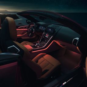 BMW M8 Competition Cabrio, interni F91. BMW M8 Competition Cabrio con capote aperta, interni con luce ambiente rossa di notte F91.