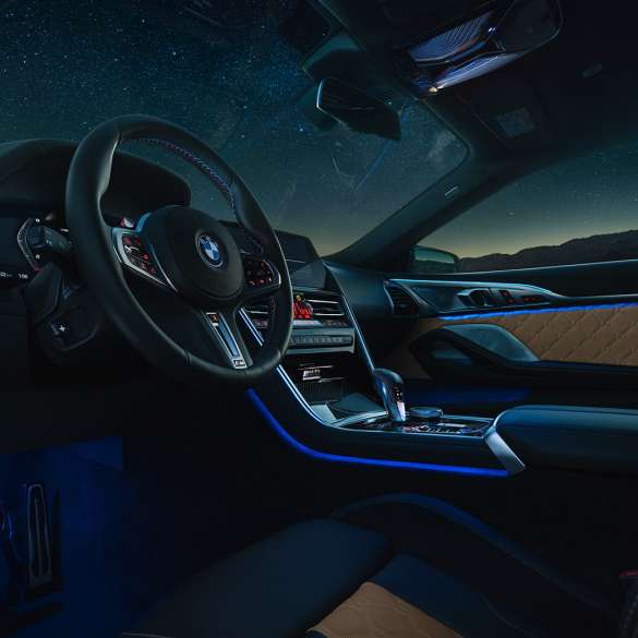 BMW M8 Competition Coupé, cockpit F92. BMW M8 Competition Coupé, cockpit di notte con volante in pelle M e luce ambiente blu F92.