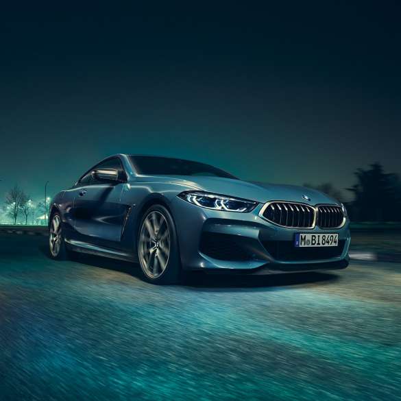 BMW M850i xDrive Coupé, vista frontale di tre quarti da sinistra G15. BMW M850i xDrive Coupé in Barcelona Blue metallizzato, vista frontale di tre quarti da sinistra, in marcia di notte G15.