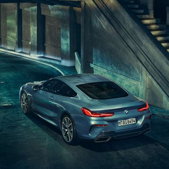 BMW M850i xDrive Coupé, vista posteriore di tre quarti da sinistra G15. BMW M850i xDrive Coupé in Barcelona Blue metallizzato, vista posteriore di tre quarti da sinistra, in sosta di notte G15.