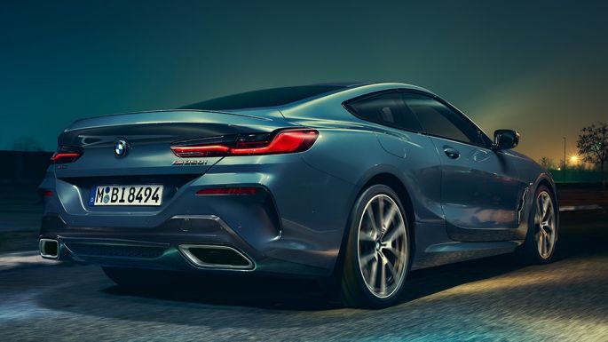 BMW M850i xDrive Coupé, vista posteriore G15. BMW M850i xDrive Coupé in Barcelona Blue metallizzato, vista posteriore, in marcia di notte G15.