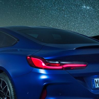 Spoiler posteriore M F92. BMW M8 Competition Coupé in Marina Bay Blue metallizzato, primo piano notturno delle spalle con spoiler posteriore in carbonio F92.