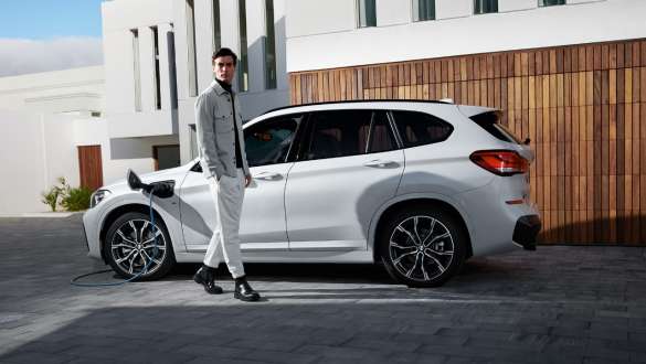 BMW X1 xDrive25e F48 ibrida Plug-in vista laterale in ricarica BMW X1 xDrive25e F48 ibrida Plug-in vista laterale in ricarica con fotomodella