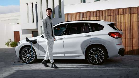 BMW X1 xDrive25e F48 LCI ibrida Plug-in Vista laterale in ricarica BMW X1 xDrive25e F48 LCI ibrida Plug-in Vista laterale in ricarica con fotomodella