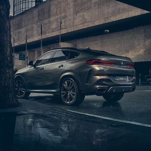 Esterni della BMW X6 SUV G06. BMW X6 SUV, vista posteriore a tre quarti in ambiente urbano G06.