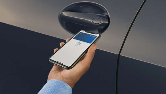 Comfort Access System con una mano che tiene uno smartphone vicino alla maniglia della portiera della BMW X7 G07 LCI Comfort Access System con una mano che tiene uno smartphone vicino alla maniglia della portiera della BMW X7 G07 LCI