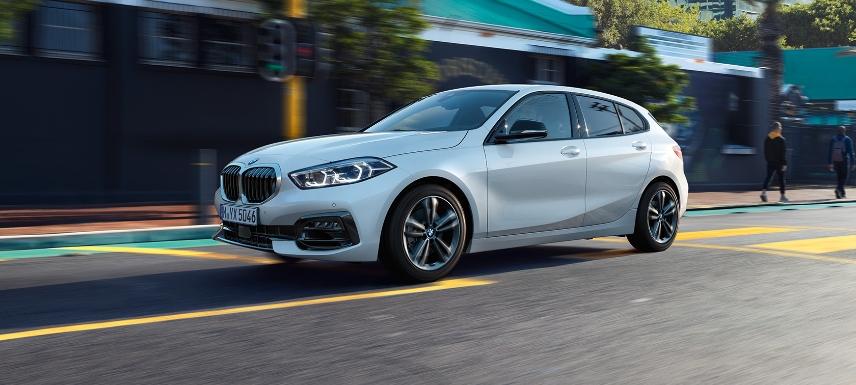 BMW Serie 1, Versione Sport, vista laterale a tre quarti F40. BMW Serie 1, Versione Sport in Mineral White metallizzato, vista laterale a tre quarti in movimento F40.