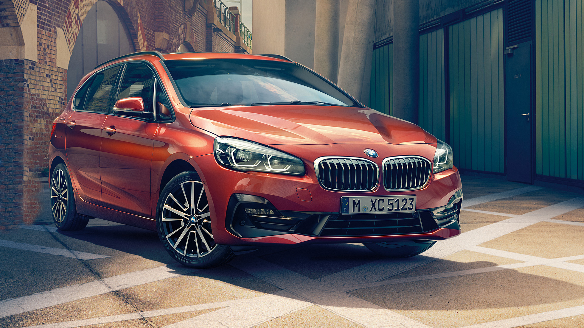 Esterni della BMW Serie 2 Active Tourer F45 BMW Serie 2 Active Tourer F45 Facelift 2018 Sunset Orange metallizzato vista anteriore a tre quarti parcheggiata in strada
