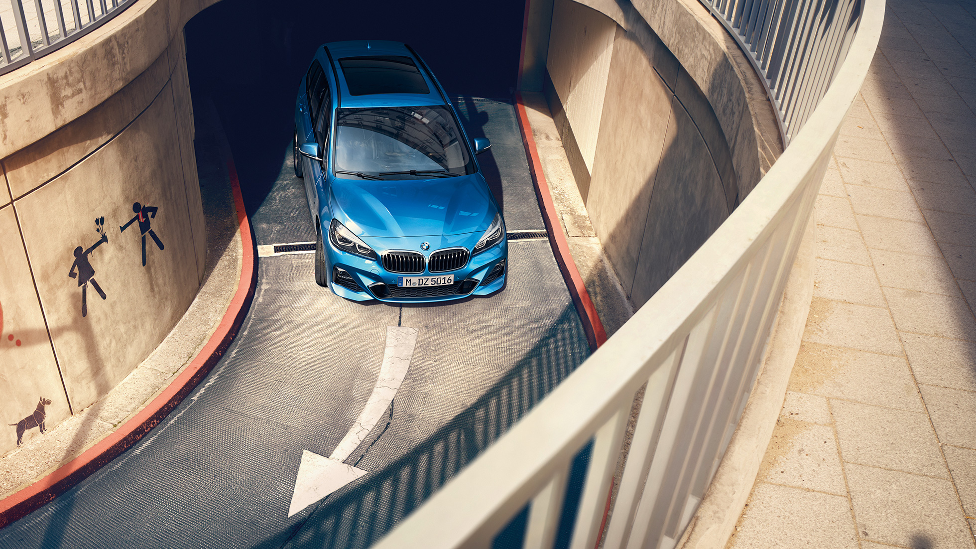 BMW Serie 2 Gran Tourer in movimento in un autosilo F46 BMW Serie 2 Gran Tourer F46 Facelift 2018 Misano Blue metallizzato con prospettiva a volo di uccello in movimento in un autosilo
