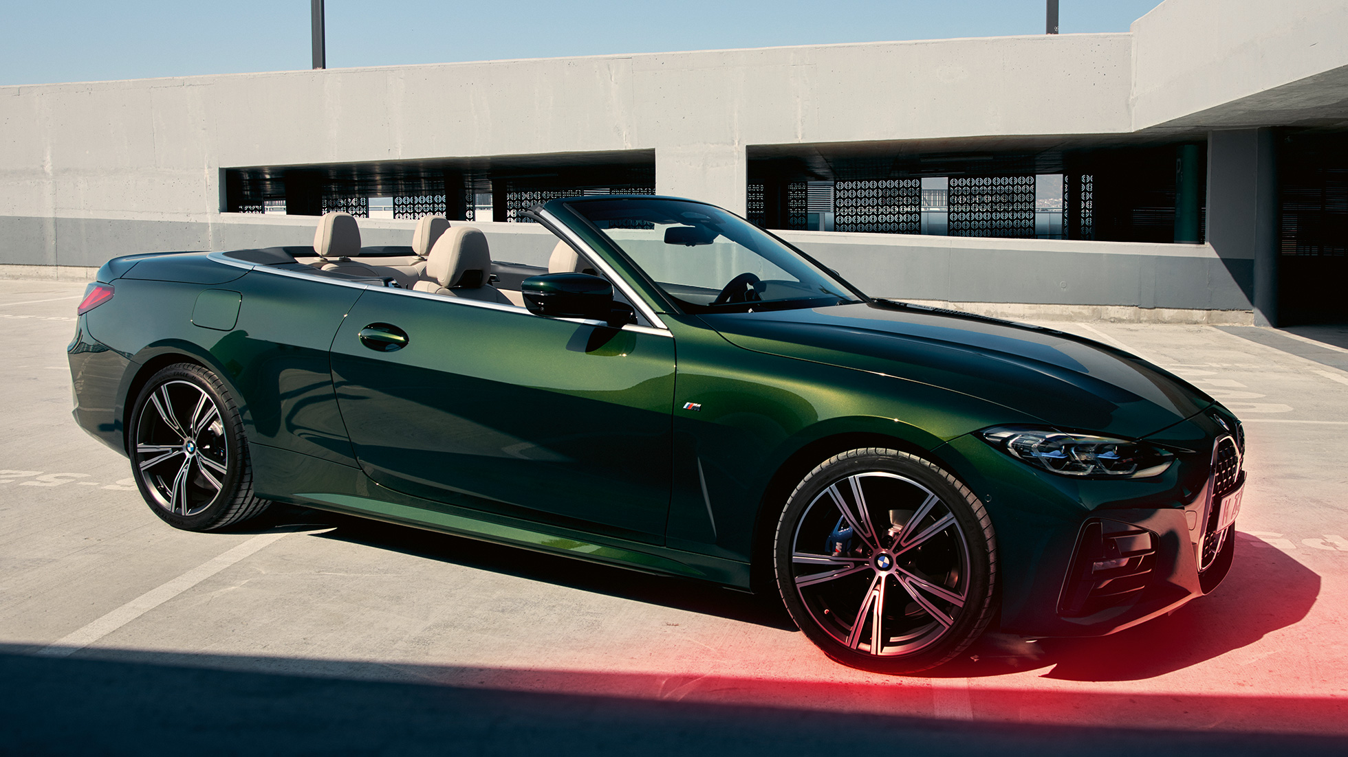 Vista anteriore a tre quarti della BMW Serie 4 Cabrio G23 2020 con uomo BMW Serie 4 Cabrio G23 2020 Sanremo Green metallizzato Vista anteriore a tre quarti a fianco di un uomo