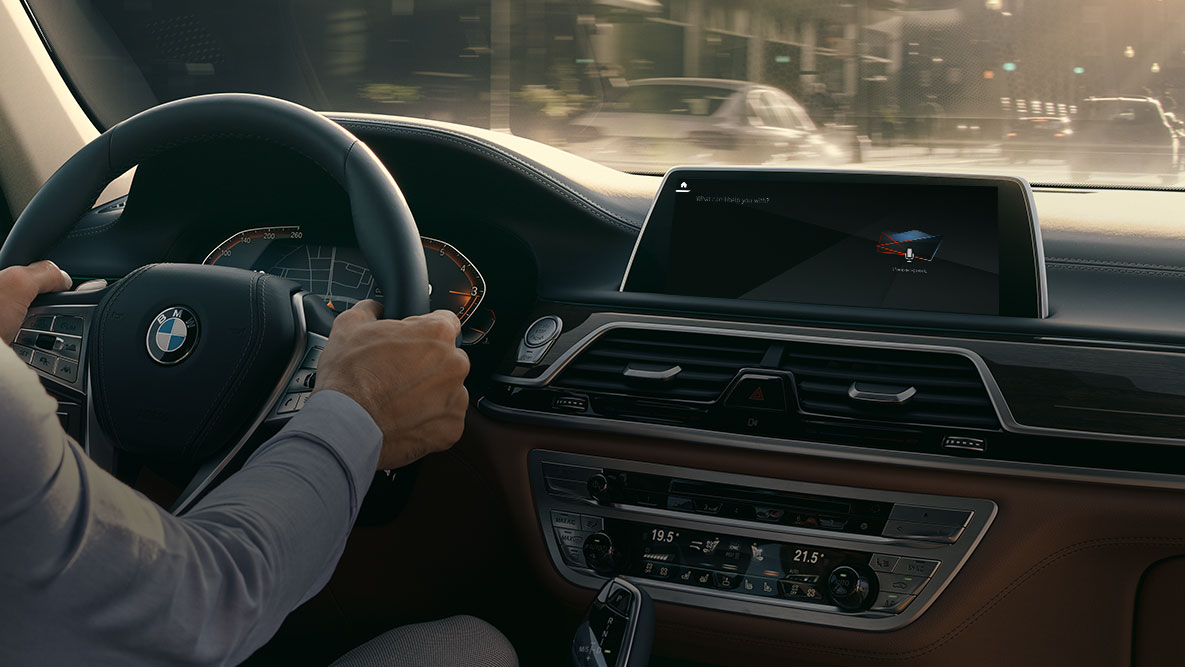BMW Intelligent Personal Assistant BMW Intelligent Personal Assistant: Uomo alla guida in BMW, primo piano del Live Cockpit Professional