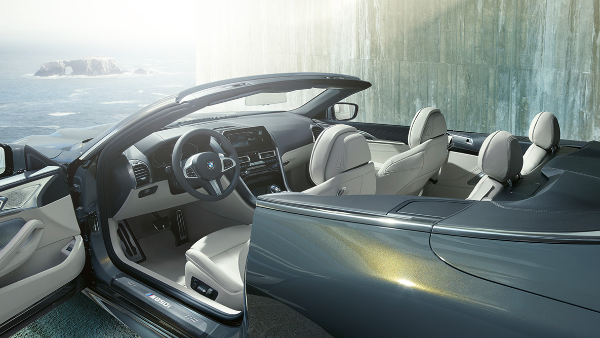 BMW M850i xDrive Dravit Grey metallic, interni, capote in tessuto e portiera aperta. BMW M850i xDrive Dravit Grey metallic, interni, capote in tessuto e portiera aperta.