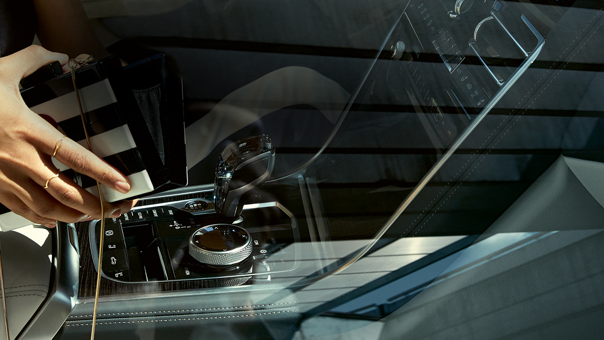 Interni della BMW M850i xDrive, applicazione in vetro CraftedClarity, donna con borsetta aperta. Interni della BMW M850i xDrive, applicazione in vetro CraftedClarity, donna con borsetta aperta.
