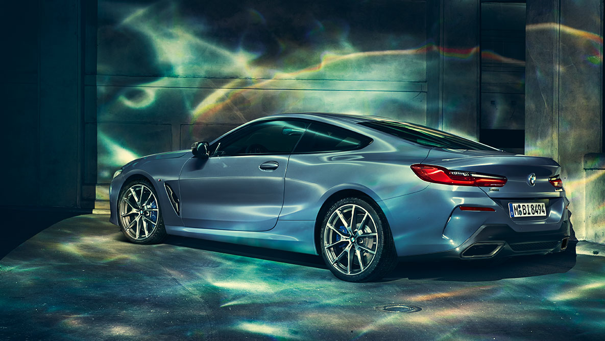 BMW Serie 8 Coupé, ripresa posteriore a tre quarti. Ripresa posteriore a tre quarti della BMW Serie 8 Coupé di notte su sfondo urbano.