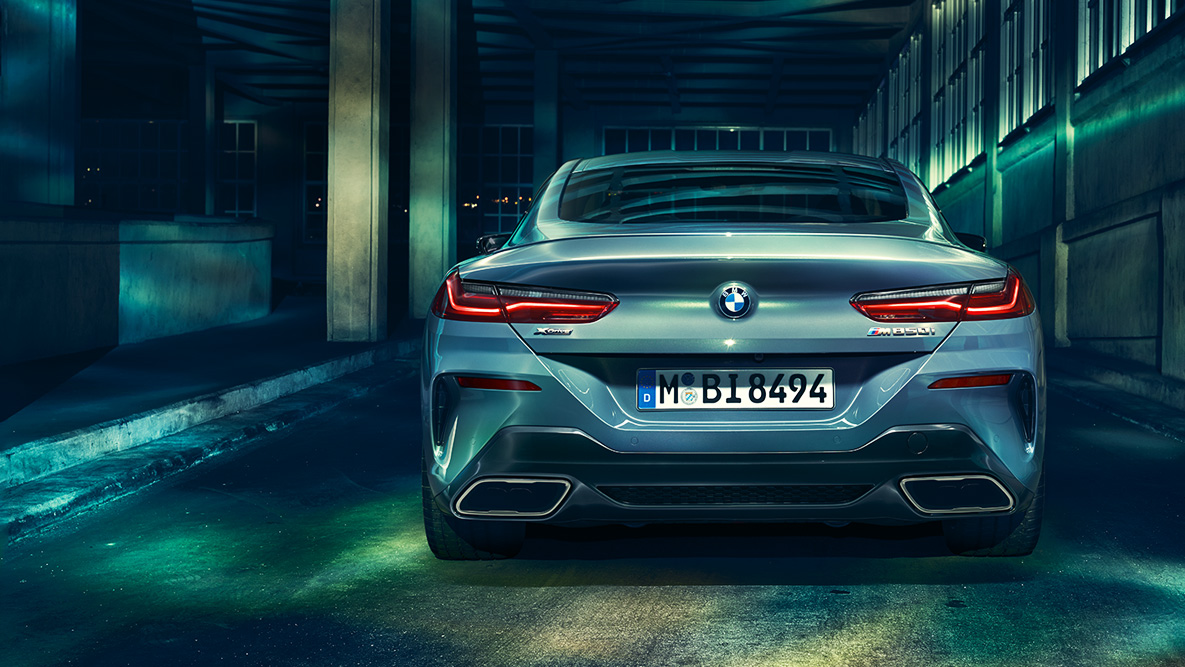 BMW Serie 8 Coupé, vista posteriore Vista posteriore della BMW Serie 8 Coupé di notte su sfondo urbano.