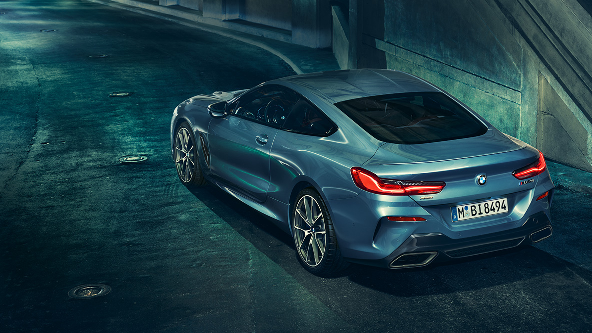 BMW Serie 8 Coupé, ripresa posteriore a tre quarti. Ripresa posteriore a tre quarti della BMW Serie 8 Coupé di notte su sfondo urbano.
