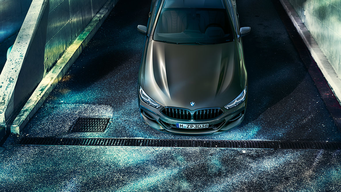 Ripresa frontale da ferma della BMW Serie 8 Coupé. Ripresa da ferma anteriore della BMW Serie 8 Coupé con allestimento BMW Individual di notte su sfondo urbano.
