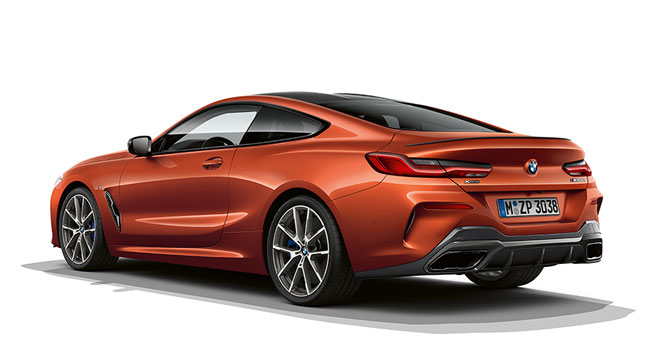 Ripresa da ferma della BMW Serie 8 Coupé in Sunset Orange metallizzato su sfondo bianco.