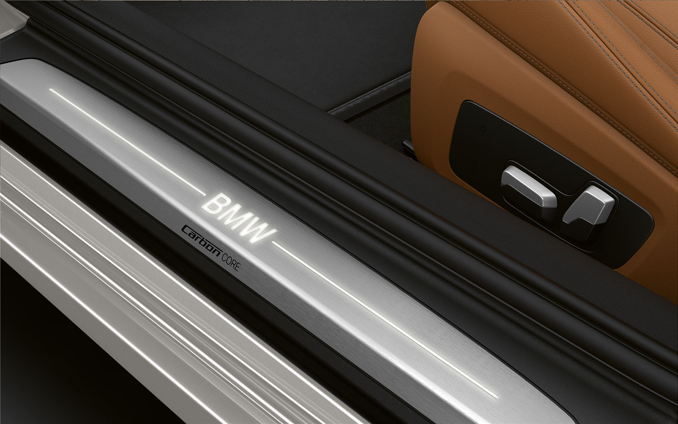 BMW Serie 8 Coupé, logo BMW con logo BMW G15. Ripresa da vicino del listello battitacco della BMW Serie 8 Coupé con logo BMW G15.