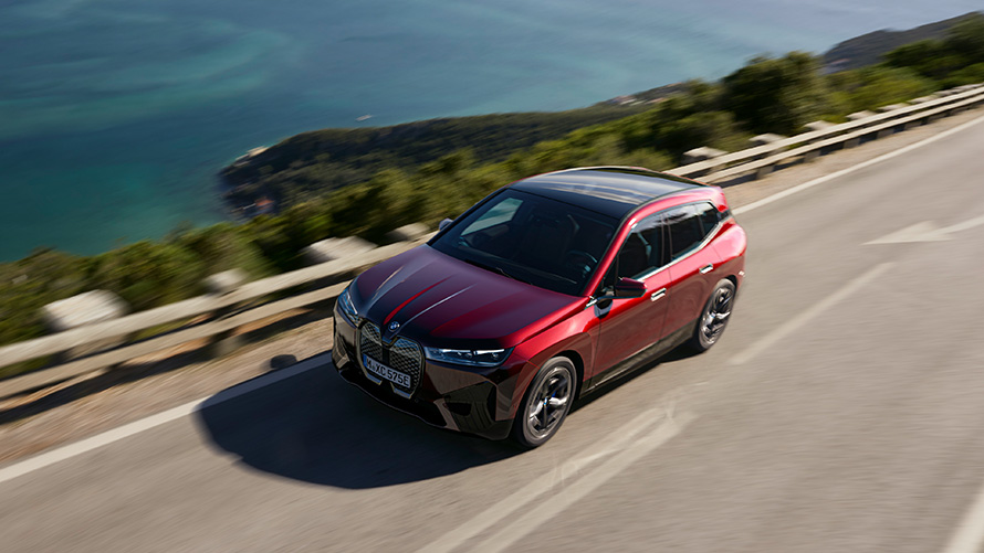 SUV elettrico BMW iX i20 2021 BMW iX xDrive50 Aventurine Red in movimento su strada Performance