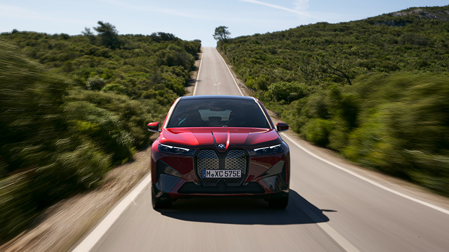SUV elettrico BMW iX i20 2021 BMW iX xDrive50 Aventurine Red in movimento su strada Autonomia