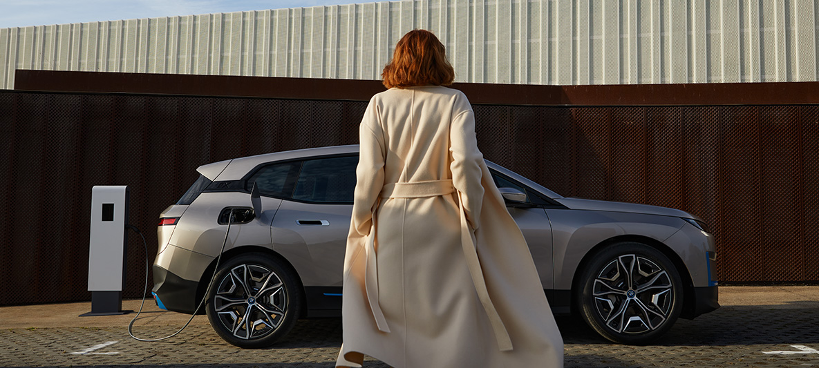 BMW iX vista laterale BMW iX Cashmere Silver i20 vista laterale con modello frontale