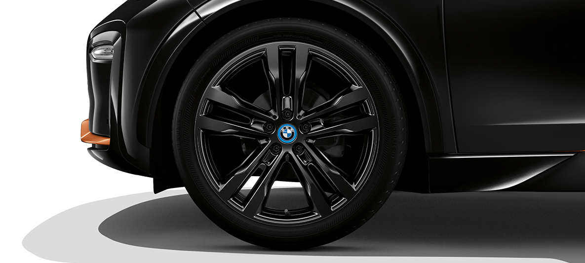 BMW i3s Edition RoadStyle vista laterale frontale con cerchio BMW i3s Edition RoadStyle Fluid Black con profilo in E-Copper vista laterale frontale con cerchio