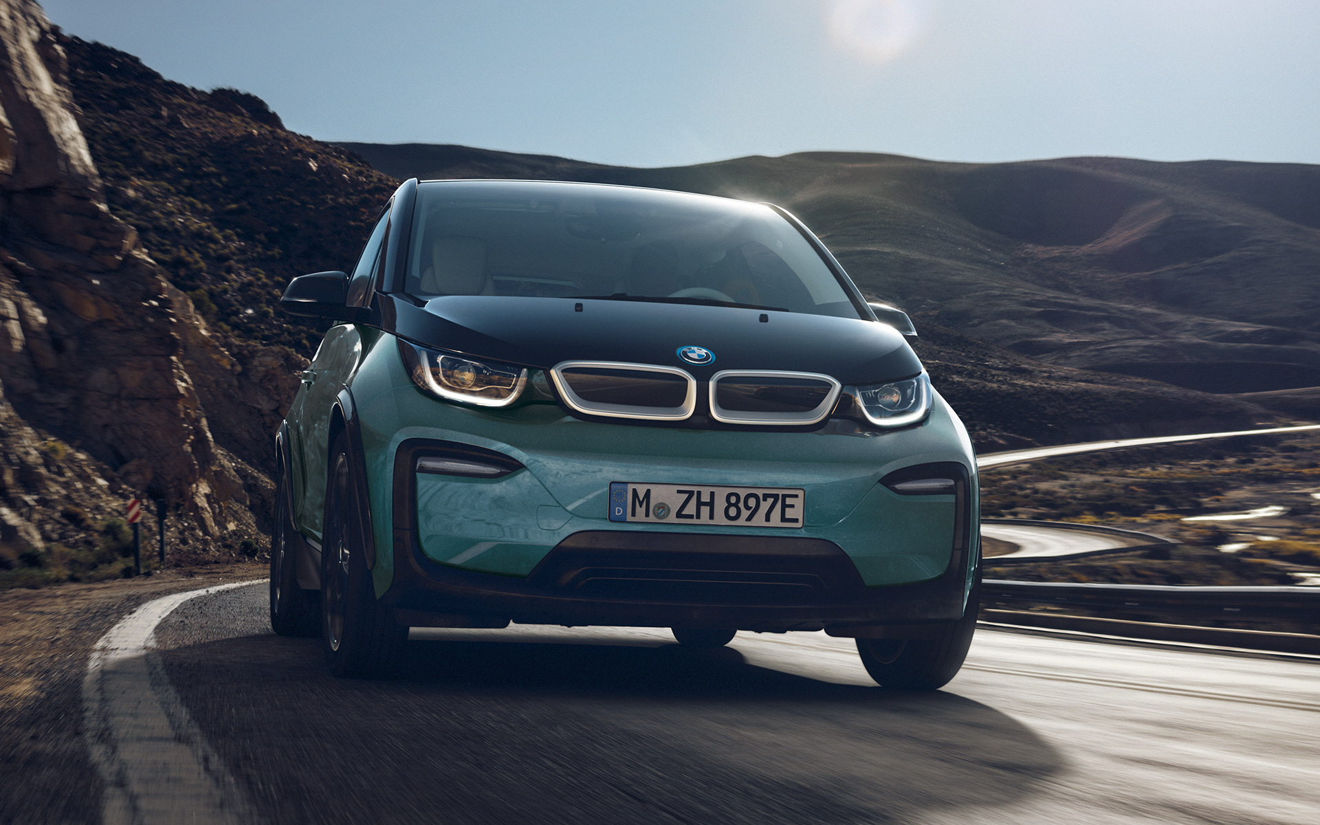 BMW i3 I01 2018 Blue Ridge Mountain con profilo in Frozen Grey metallizzato vista laterale in movimento su sfondo urbano