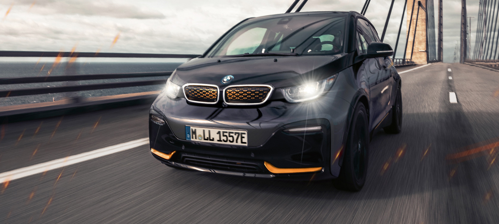 BMW i3 Unique Forever Edition I01 Storm Bay con profilo Frozen E-Copper metallizzato vista anteriore a tre quarti in movimento su strada